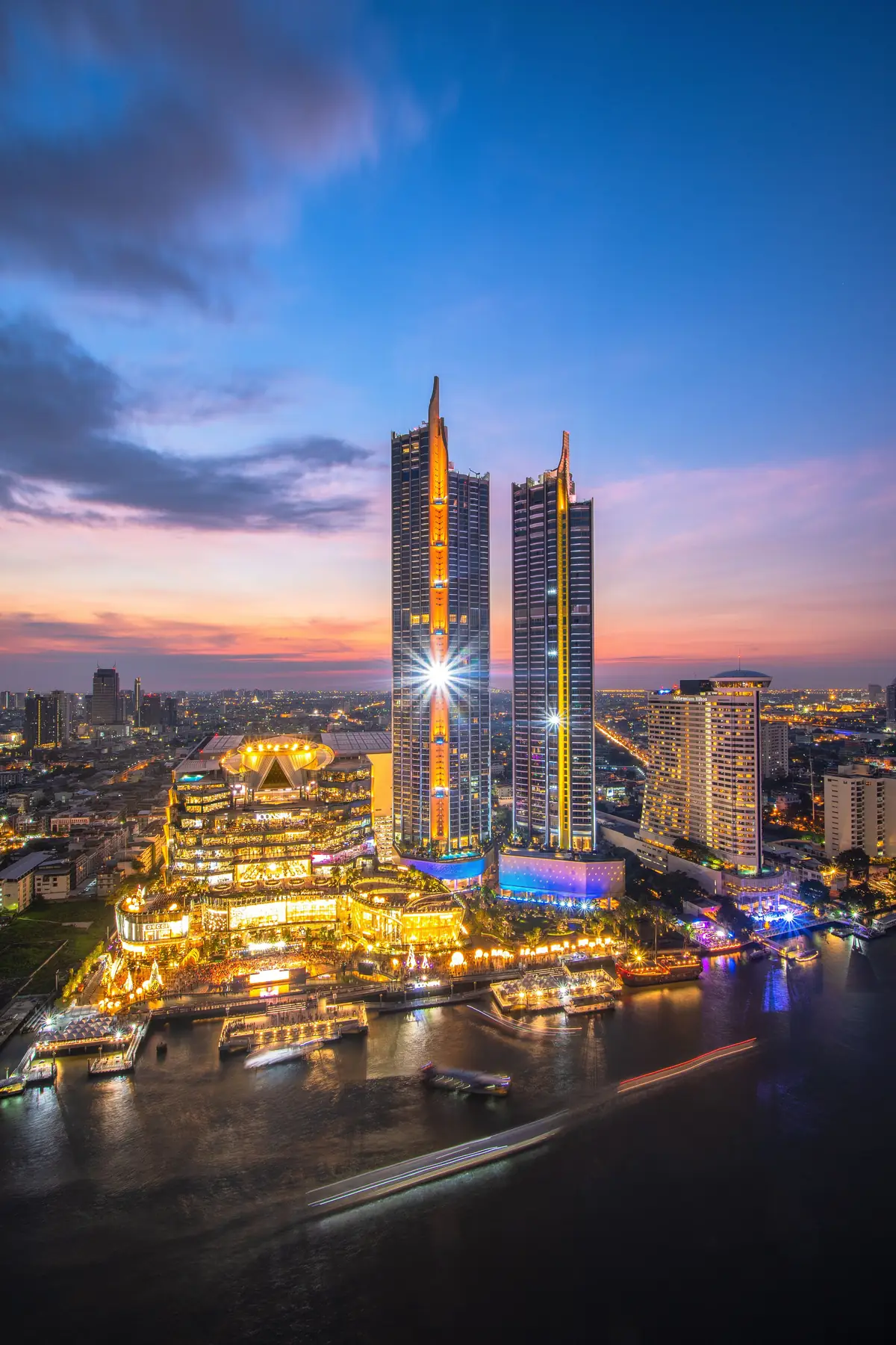 ICONSIAM towers lit at dusk on the Chao Phraya River in the Riverside district of Bangkok, Thailand