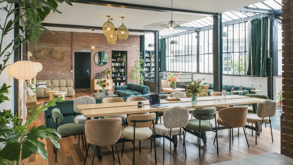 A plant-filled converted printworks with long timber tables, Paris 11th