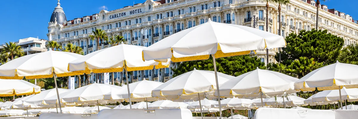 Parasols and loungers at Vilebrequin la plage with the Carlton behind, Cannes