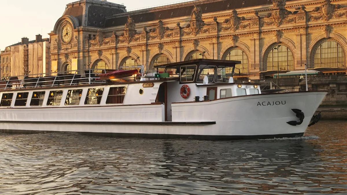 A Yachts de Paris vessel on the Seine at sunset