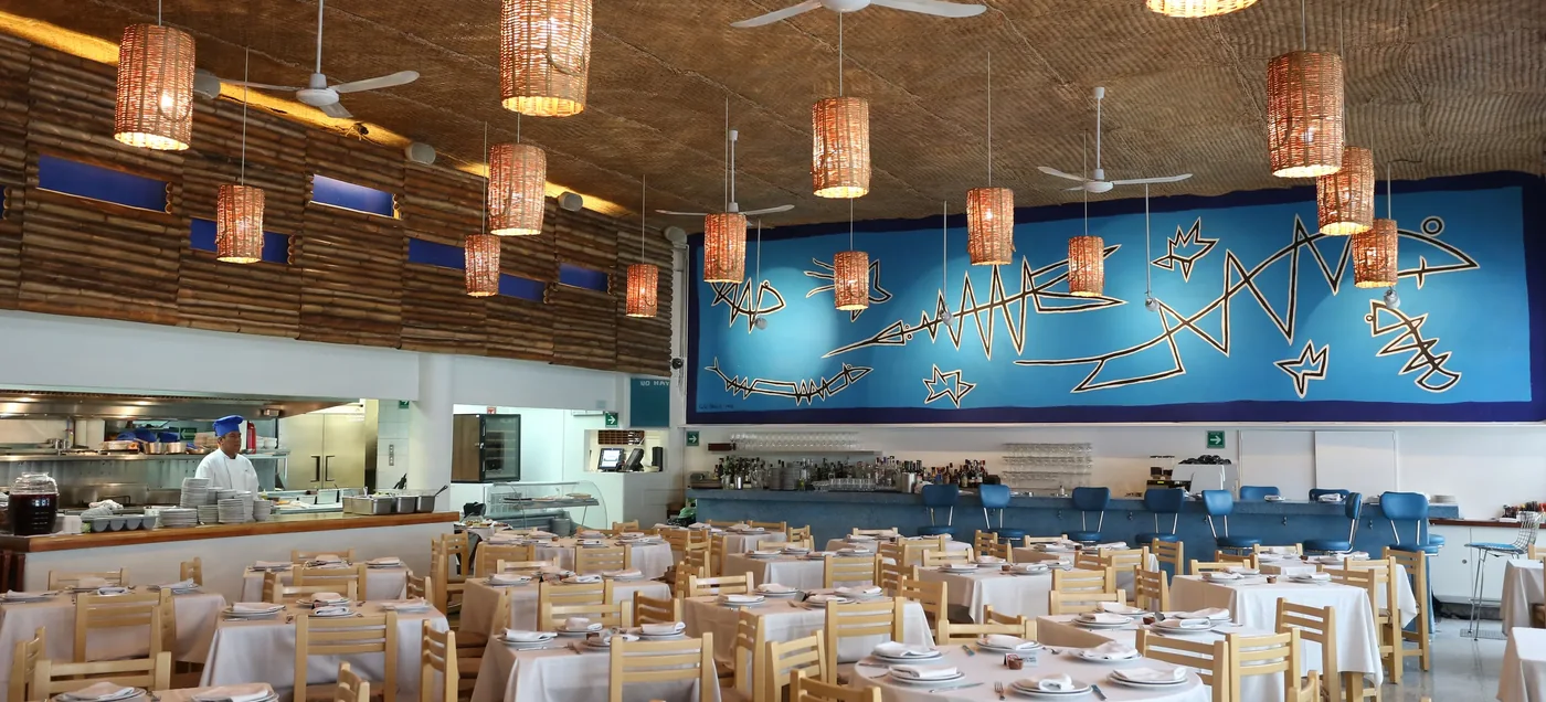 Dining room with a woven ceiling, rattan pendant lights and a blue mural at Contramar, Roma Norte, Mexico City