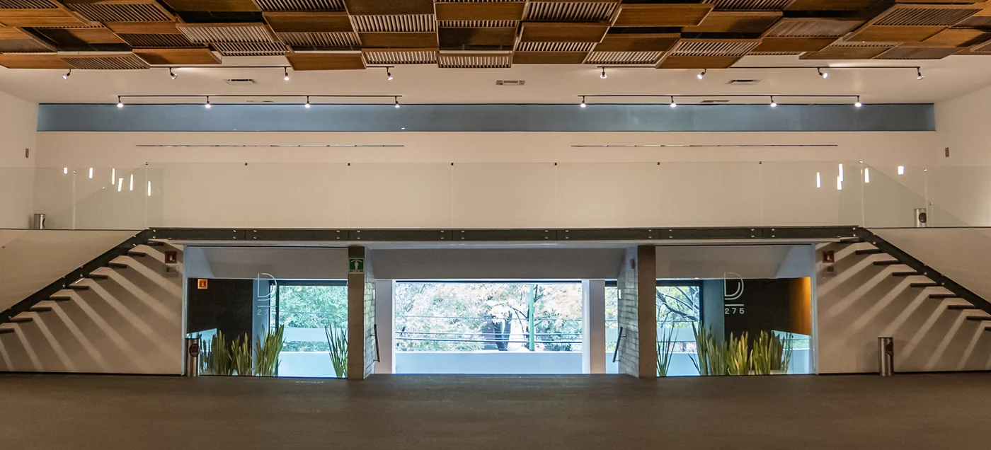 The event floor at Durango 275 in Roma Norte, Mexico City, with twin staircases and full-height glass doors