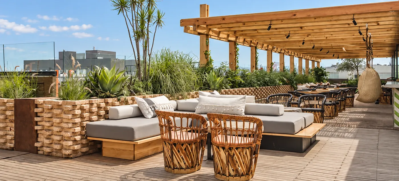 Rooftop terrace with a timber pergola, planted beds and lounge seating at Toledo Rooftop, Juárez, Mexico City