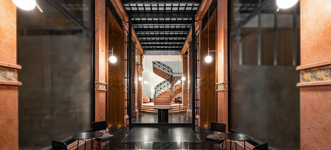 Mosaic-inlaid stone columns and the sweeping marble staircase at the entrance of Umbral, Curio Collection, Centro Histórico, Mexico City