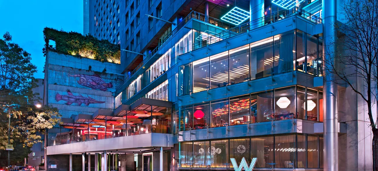 The lit glass and steel facade of W Mexico City on Campos Elíseos, Polanco, at dusk